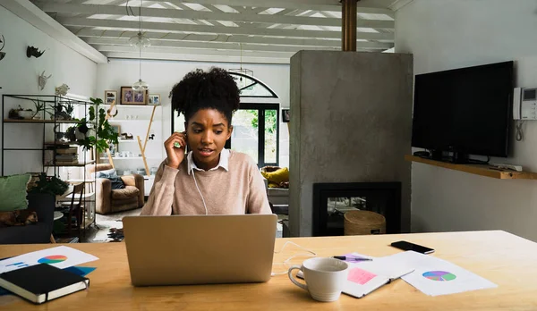 Concerned female business woman wearing earphones chatting on video call next to paper work and hot cut of coffee in fancy living room. — стоковое фото