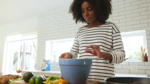 Красивая молодая женщина, разбивающая яйца, смешивающая и пекающая дома на кухне — стоковое видео