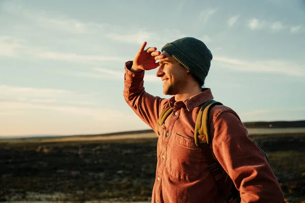 Caucasian male free spirit hiking in wilderness embracing nature searching in the distance — Stock Photo, Image