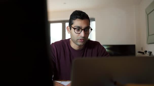 Gemischter Geschäftsmann, der von zu Hause aus arbeitet, winkt beim Videoanruf mit Laptop — Stockvideo