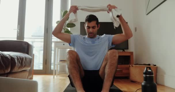 Maschio razza mista che lavora in soggiorno tenendo asciugamano sudore — Video Stock