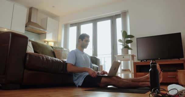 Mixte homme assis sur le sol dans le salon se préparant pour l'exercice tenant planche — Video
