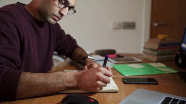 Mieszany człowiek biznesu wyścigowego za pomocą pisania pióra na notatniku sortowanie admin podczas pracy w domu — Wideo stockowe