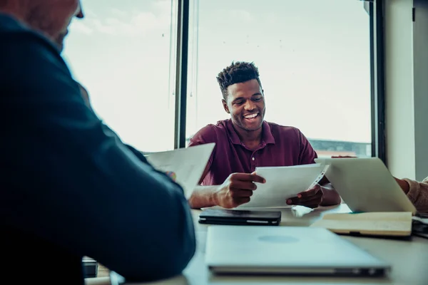 Male business man laughing with team of colleagues discussing points to improve business — 图库照片