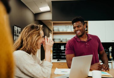 Beyaz iş kadını karışık ırktan meslektaşıyla gülüyor konferans toplantısında sunuma hazırlanıyor.