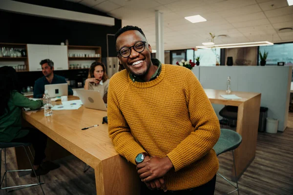 Karışık ırk işadamı, öğle yemeği arasında iş arkadaşlarıyla sohbet ederken gülümsüyor.