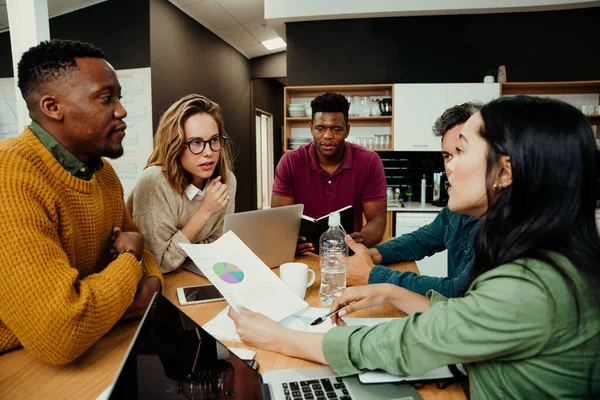 Diversi team si sono riuniti durante le pause pranzo lavorando sulla ricerca di laptop attraverso documenti che discutono di lavoro — Foto Stock