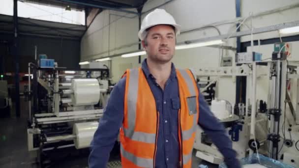 Férfi mérnök dolgozik elfoglalt gyárban áll mosolyogva keresztbe tett karokkal a raktárban — Stock videók