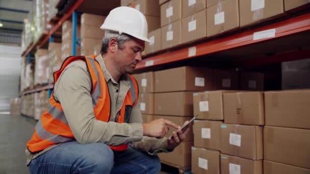 Bělošský muž pracovník zaškrtnutí balíček kontrolní seznam na digitální tablet e-mail manažer, zatímco sedí v uličce továrny shop — Stock video