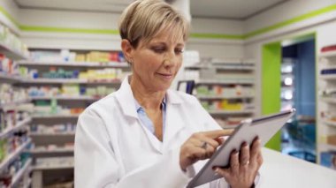 Kadın doktor eczanede beyaz yulaf takan müşterilerin e-postalarına bakıyor. 