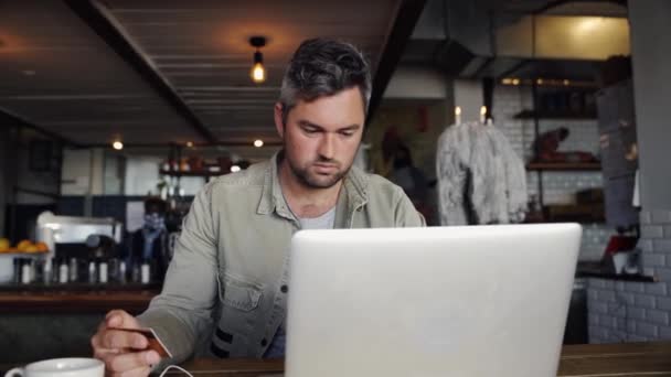 Üzletember kezében hitelkártya online fizetés laptop ül a kávézóban. — Stock videók