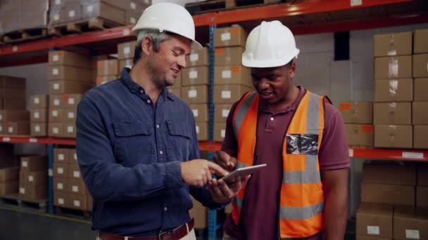 Ispettore e collega scorrendo le e-mail su tablet digitale discutendo di piani aziendali in piedi in fabbrica — Video Stock