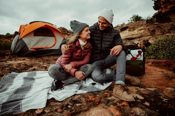 Caucasian romantic couple camping in wilderness cuddling