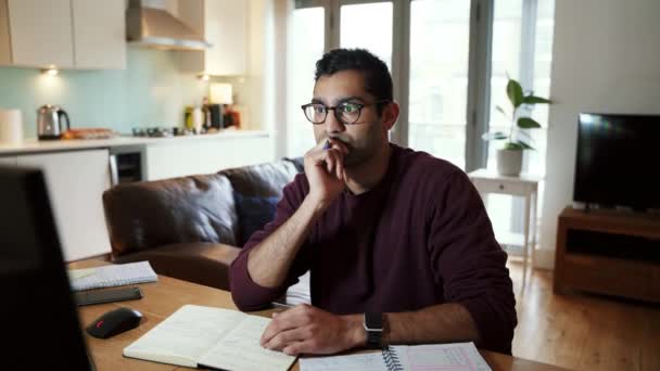 Mixed race determined business man writing in note pad stretching with hands behind head — Video