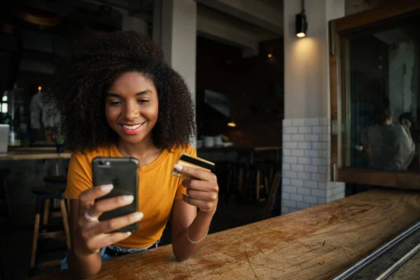 Sorridente femmina razza mista pronto a pagare per il caffè al negozio di caffè alla moda — Foto Stock