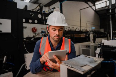Kafkasyalı erkek mühendis, çelik kalıpları üzerine dijital tablet tekniklerini araştırıyor..