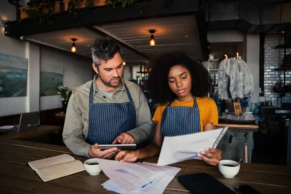 Preoccupato collega di sesso maschile e femminile guardando le finanze in autentica caffetteria. — Foto Stock