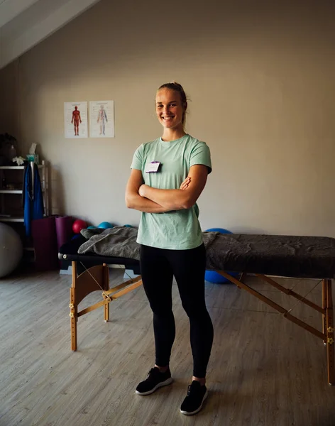 Volledig lichaamsportret van een gezonde stagiaire in de fitnessruimte wachtend op haar eerste gewonde patiënt. — Stockfoto