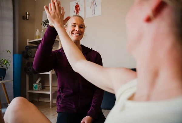 Patiënt en therapeut high five na zweterige training in Pilates studio — Stockfoto