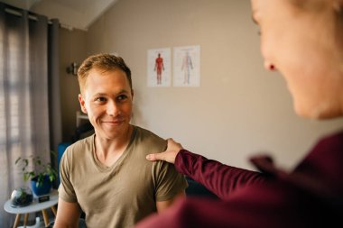 female personal training greeting patient smiling in pilates studio before exercising 