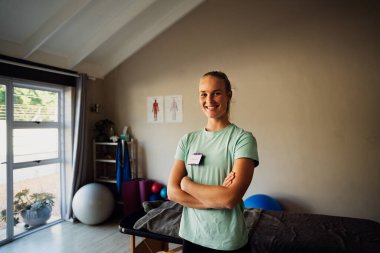 Portrait of Caucasian female physiotherapist at home practice, smiling and happy