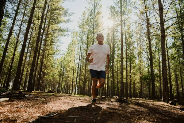 Male caucasian pensioner running in the woods