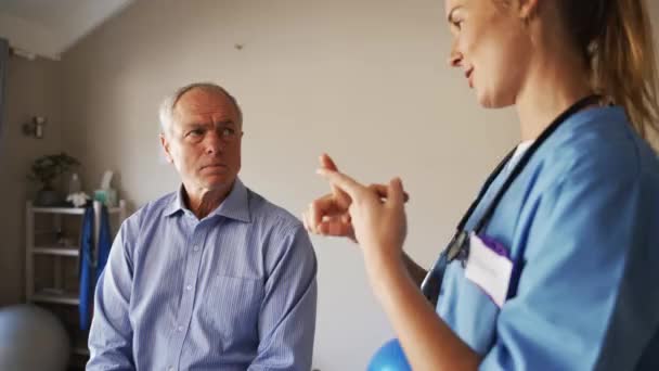 Γυναίκα ιατρός συζητά συμβουλές για ηλικιωμένους άνδρες ασθενή. — Αρχείο Βίντεο