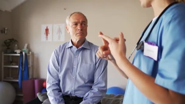 Female nurse advising elderly man on healthy lifestyle. — Stockvideo