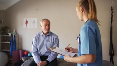 female doctor does knee flexibility exam and takes down result.