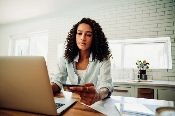 Mixed race female student holding credit card typing on laptop sitting in kitchen — Foto Stock