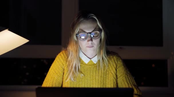 Blanke free lance werknemer vrouw zitten aan bureau lezen van laptop werken laat in de avond — Stockvideo