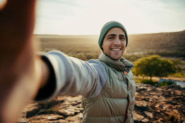 Caucasian young male taking selfie while camping in wilderness enjoying sunset — Stock Photo, Image