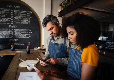 Sayısal tablet taşıyan kağıt işlerine bakan melez ırk meslektaşları moda kahve dükkanlarının banka hesaplarını yönetiyorlar.