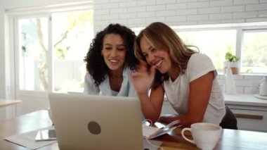 Mutfakta çalışan melez bayan arkadaşlar dizüstü bilgisayardan video çağrısı yapıyorlar.
