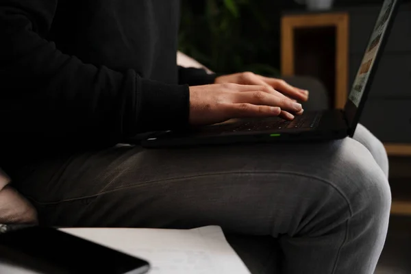 Young caucasian male typing on laptop studying for online school sitting in relaxed bedroom — 图库照片