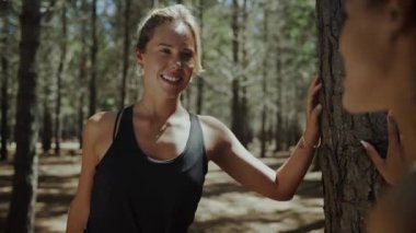 Karışık ırk kız arkadaşları uzun koşuya çıkmadan önce ormanda esniyorlar ve sohbet ediyorlar.