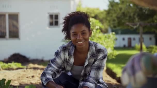 Karışık ırk kadını dışarıda erkek meslektaşıyla sebze bahçesinde çalışıyor. — Stok video
