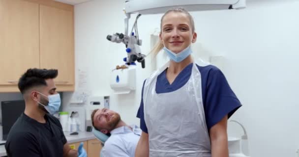 Kavkazská zubařka stojící na klinice s mužským klientem usmívajícím se se zkříženýma rukama — Stock video