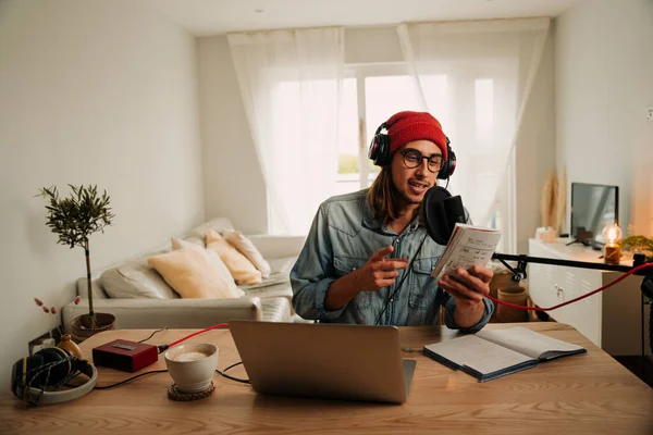 Caucasian male freelance podcaster recording series in home office lounge using microphone and headphones — Zdjęcie stockowe
