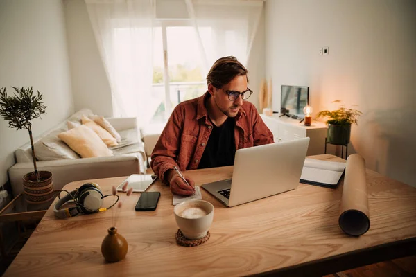 Caucasian male studying online working from home on laptop during lockdown — Zdjęcie stockowe