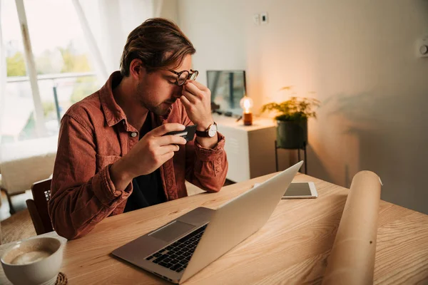 白人男性ビジネスマンはデスクに座ってノートパソコンに入力して仕事をするのに疲れた — ストック写真