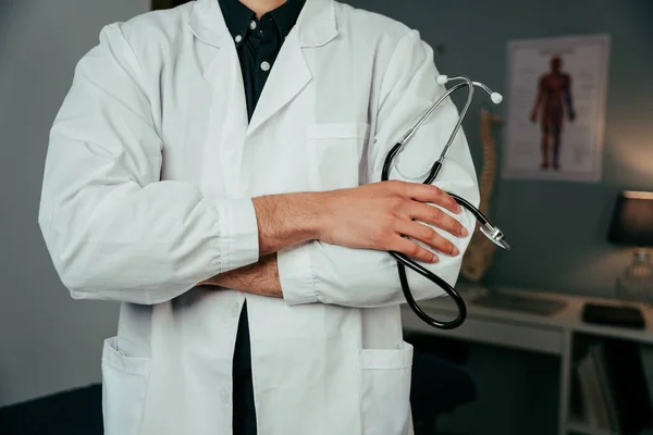 Close up mixed race male doctor standing in office with arms crossed — Φωτογραφία Αρχείου