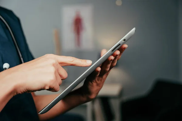 Blanke vrouwelijke verpleegkundige typen op digitale tablet in kliniek — Stockfoto