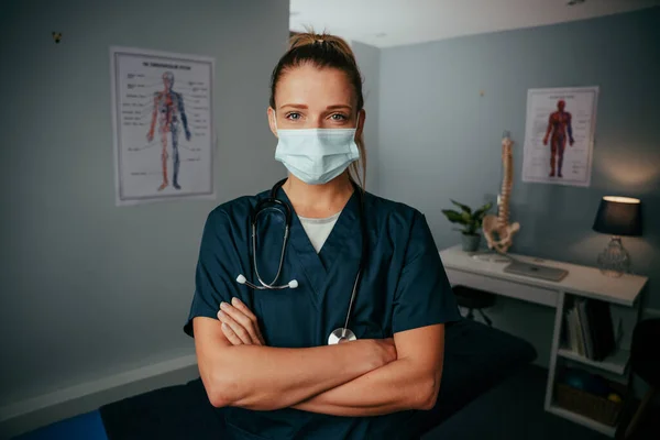 Λευκή γυναίκα νοσοκόμα στέκεται στο ιατρείο φορώντας χειρουργική μάσκα — Φωτογραφία Αρχείου