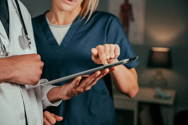 Close up caucasian nurse chatting with male doctor in clinic