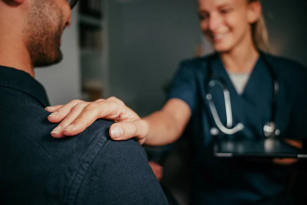 Infirmière blanche tenant l'épaule du patient masculin — Photo