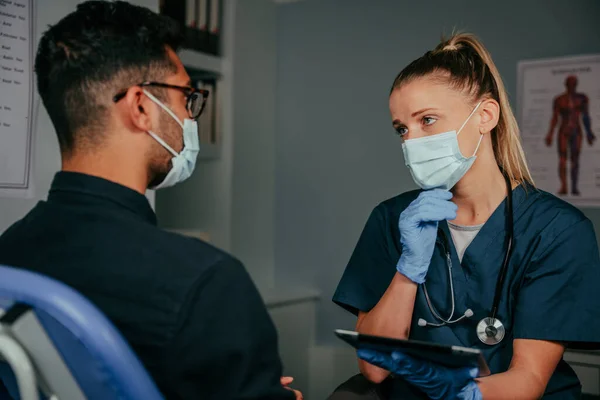 Mixte race mâle patient bavarder avec infirmière — Photo