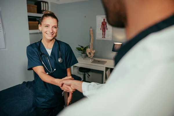 Blanke vrouwelijke verpleegster schudden handen met mannelijke arts — Stockfoto