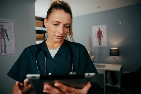 Blanke vrouwelijke verpleegkundige onderzoek op digitale tablet — Stockfoto