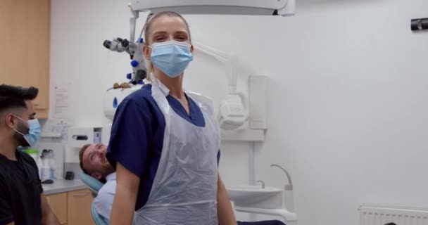 Белая медсестра, стоящая в комнате стоматолога со скрещенными руками — стоковое видео